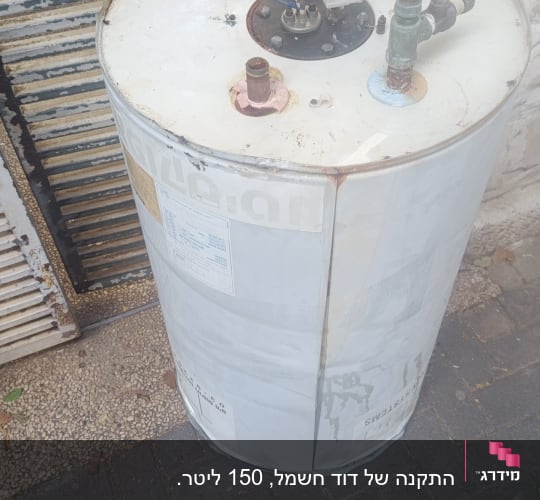 דוד שמש עם חיבורים וצינורות על רצפה מרוצפת